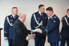 Starosta Miechowski Jacek Kobyłka wręcza mł. insp. Michałowi Gurdzie pamiątkę związaną z ziemią miechowską