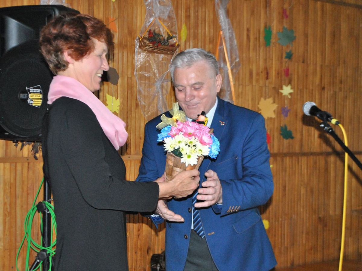 Teresa Libera odbiera kwiaty od wójta Kozłowa z okazji I Gminnego Dnia Seniora - fot. GOK Kozłów